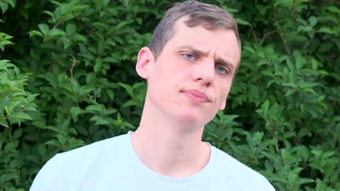 Charming young blond guy with blue eyes frowns and disapprovingly shakes head Video stock 134170382