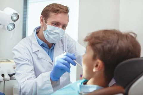 Charming young boy getting teeth checkup at the dentist Stock Photos