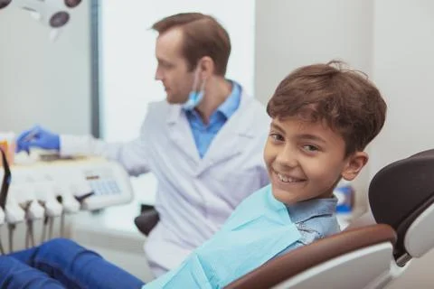 Charming young boy getting teeth checkup at the dentist Stock Photos