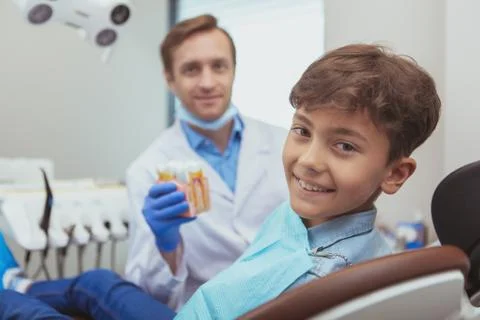 Charming young boy getting teeth checkup at the dentist Stock Photos