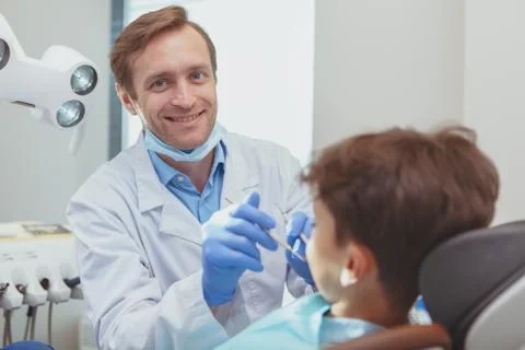 Charming young boy getting teeth checkup at the dentist Stock Photos