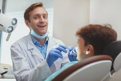 Charming young boy getting teeth checkup at the dentist Stock Photos