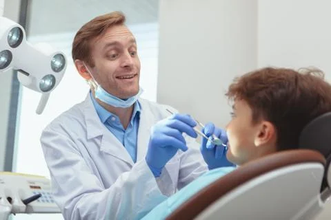 Charming young boy getting teeth checkup at the dentist Stock Photos