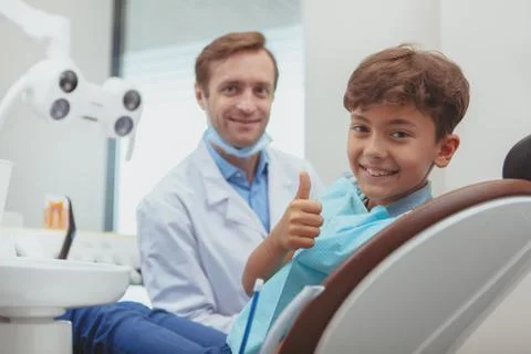 Charming young boy getting teeth checkup at the dentist Stock Photos