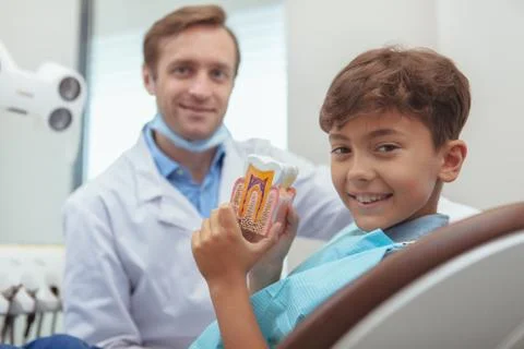 Charming young boy getting teeth checkup at the dentist Stock Photos