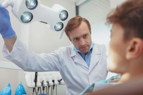 Charming young boy getting teeth checkup at the dentist Stock Photos