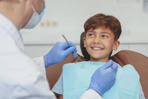 Charming young boy getting teeth checkup at the dentist Stock Photos