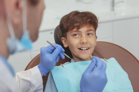 Charming young boy getting teeth checkup at the dentist Stock Photos