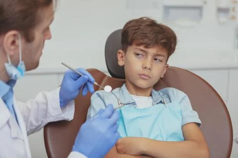 Charming young boy getting teeth checkup at the dentist Stock Photos