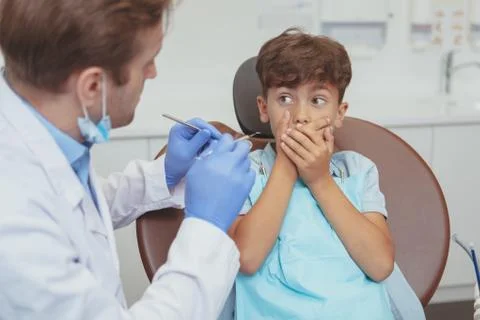 Charming young boy getting teeth checkup at the dentist Stock Photos