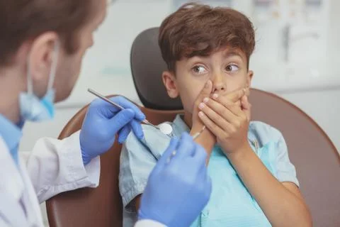 Charming young boy getting teeth checkup at the dentist Stock Photos