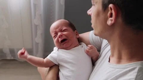 Charming young Caucasian dad wearing casual clothes holding his newborn baby Video stock 291310561