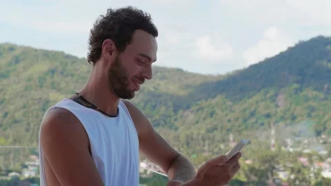 Charming young Caucasian man dressed in a casual white t-shirt, stands on his Stock Footage 219947595