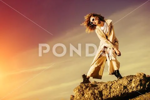 A charming young girl with curly fair hair in fashionable clothes. Fashion, b Stock Photos