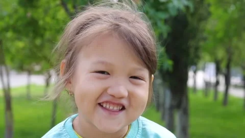 Charming young girl speaking to camera in the park Stock Footage 158490975