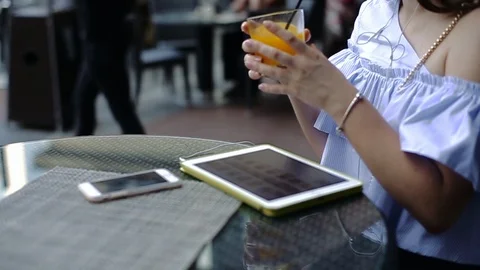 Charming young lady enjoys drinking orange juice from black plastic tube. Stock Footage 104312904