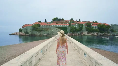 Charming young lady in hat and nice dress walking on the bridge Stock Footage 167691118