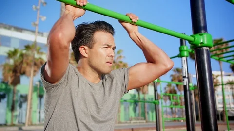 Charming young man holding horizontal bar tired after training looking pensive Video stock 109419530
