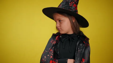 A charming young witch dressed in a vibrant festive costume, perfect for Stock Footage 315413108