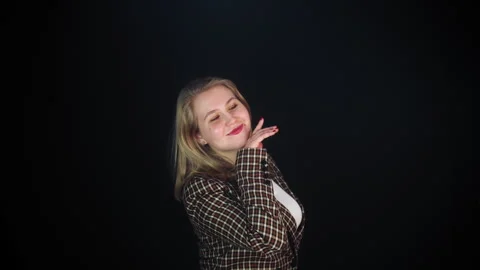 A charming young woman is posing elegantly against a dark background 库存影片 309690167