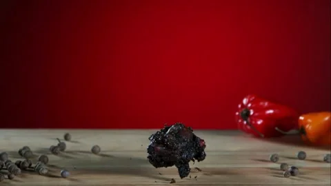 Charred chicken wing falling and bouncing on wooden table Video stock 327632085