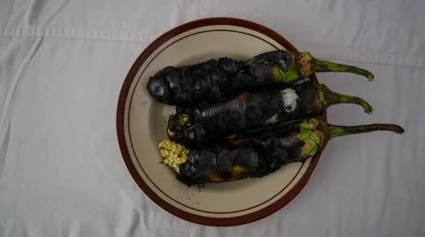 Charred eggplants on a plate, showcasing a rustic and smoky culinary preparat Foto stock