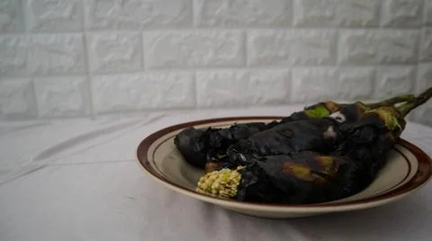 Charred eggplants on a plate, showcasing a rustic and smoky culinary preparat Foto stock