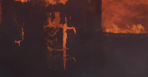 Charred end wall of a building nearly consumed by roaring flames Stock Footage 59224250