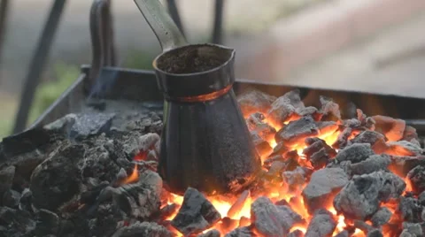 Charred pot with brewing coffee standing on fading embers Stock-Footage 7769208