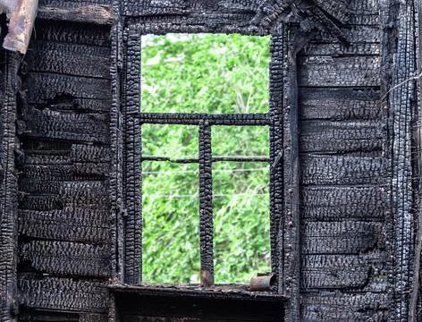 Charred window frame of a burned down house Stock Photos