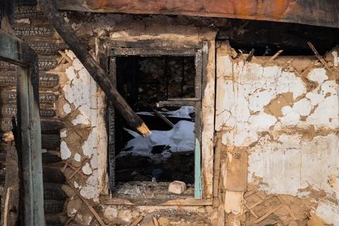 A charred window frame reveals the inside of a burned building Stock Photos
