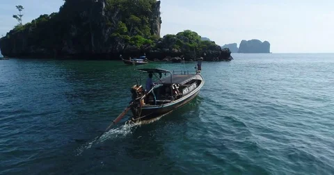 Charter longtail holding station off a karst island Видео 71301932