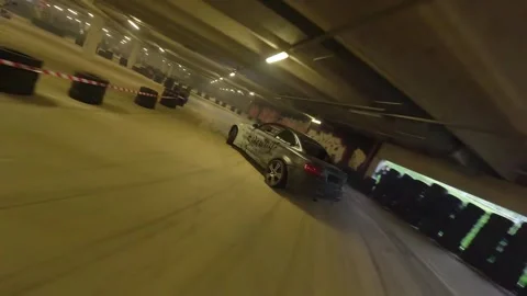 Chaser in Action: Grey-White BMW Follows Red BMW in Underground Drift Stock Footage 327031384