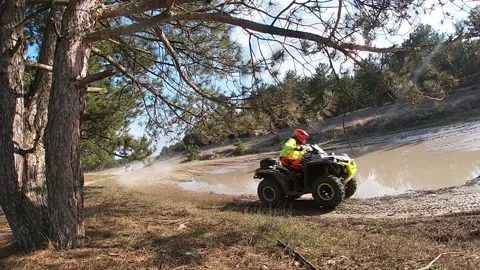 Chasing an ATV buggy cam-am through a puddle in the forest Stock Footage 159469050