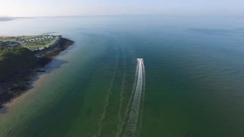 Chasing a jetski in an aerial shot at an Anglesey beach Stock Footage 234060788