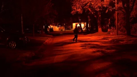 Chasing a Man Down the Street at Night Stock Footage 70725436