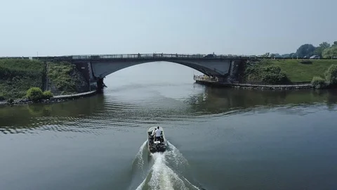 Chasing small boat under mantova bridge with drone Stock Footage 90310661