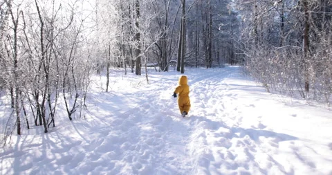 Chasing a toddler in the snow he trips and falls Stock Footage 149075636