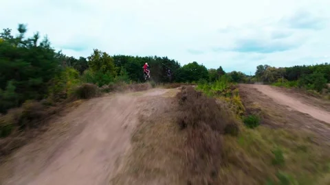 Chasing two motocross riders on a forest dirt track, using an FPV drone Stock Footage 318294266