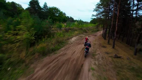 Chasing two motocross riders on a forest dirt track, using an FPV drone Stock Footage 318294277