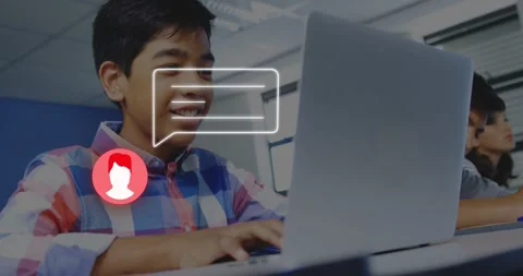 Chat bubble appearing over laptop, teen boy smiling and typing in class for Stock Footage 328330842
