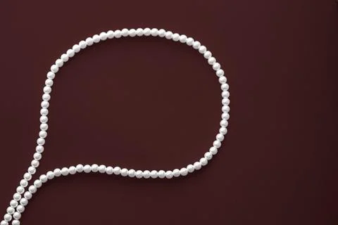 Chat message bubble made of pearl jewellery necklace on chocolate background Foto stock