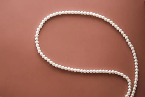 Chat message bubble made of pearl jewellery necklace on brown background Foto stock