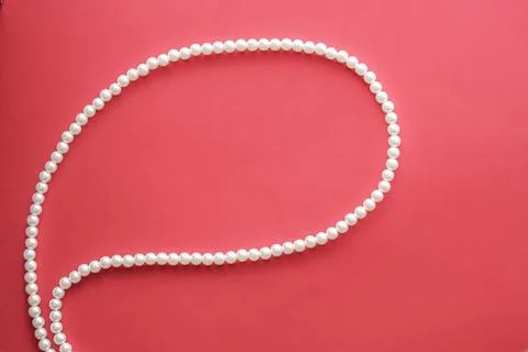 Chat message bubble made of pearl jewellery necklace on coral background Foto stock