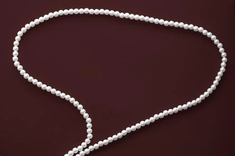 Chat message bubble made of pearl jewellery necklace on chocolate background Foto stock