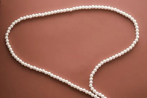 Chat message bubble made of pearl jewellery necklace on brown background Foto stock