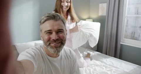 Chat with relatives. Selfie camera view of the happy adult couple sitting at the Stock Footage 156458902