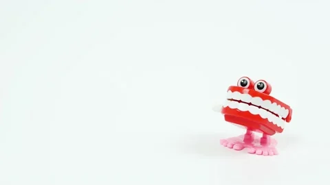 Chattering teeth toy walks into focus on the right side, white background Video stock 134313900