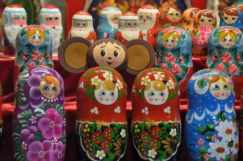 Cheburashka on the background of nesting dolls and figures of Santa Claus in Stock Photos