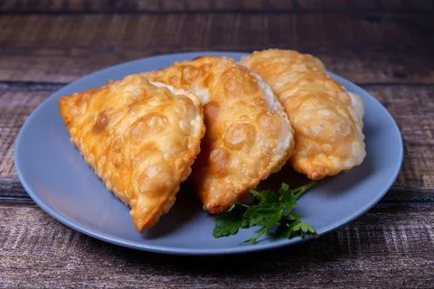 Chebureks with meat. Deep-fried flat pie. A traditional dish. Close-up. Stock Photos